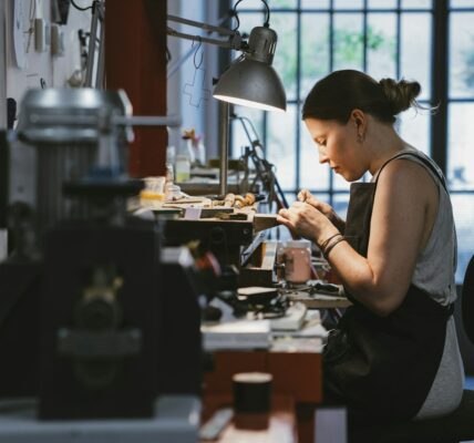 Female Jeweller At Work In Jewellery Workshop