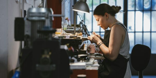 Female Jeweller At Work In Jewellery Workshop